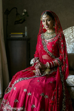 Maharani posing with her ceremony red lehenga and her jewelry. Maharani posing with her ceremony red lehenga and her jewelry.