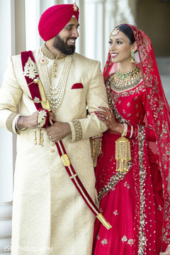 Indian bride and groom posing with their ceremony outfits. Indian bride and groom posing with their ceremony outfits.