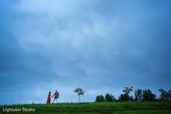 Lovely Indian bride and groom holding hands during outdoor photoshoot Lovely Indian bride and groom holding hands during outdoor photoshoot