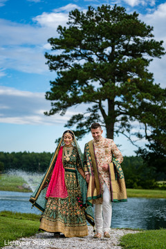 Bride and groom holding hands and smiling during outdoor photoshoot Bride and groom holding hands and smiling during outdoor photoshoot