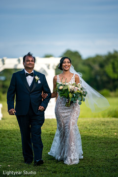 Bride walking down the aisle in the company of her father Bride walking down the aisle in the company of her father