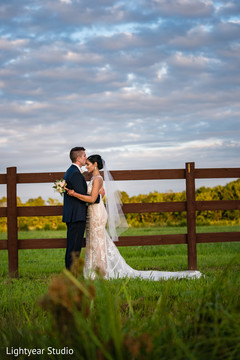Handsome groom kissing bride in the forehead during the photo session. Handsome groom kissing bride in the forehead during the photo session.