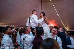 Bride and groom carried in arms during the reception party Bride and groom carried in arms during the reception party