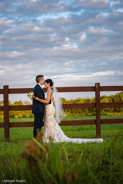 Handsome groom kissing bride in the forehead during the photo session. Handsome groom kissing bride in the forehead during the photo session.