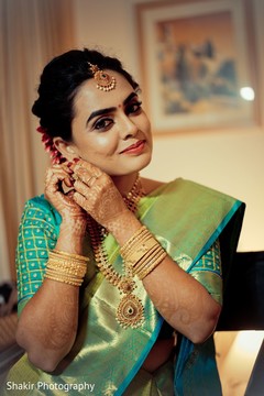 Indian bride putting earrings on Indian bride putting earrings on