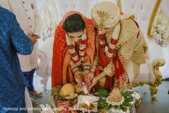 Indian bride and groom pouring rice to the sacred fire. Indian bride and groom pouring rice to the sacred fire.