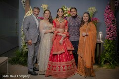 Lovely Indian bride and groom posing with guests for a portrait. Lovely Indian bride and groom posing with guests for a portrait.