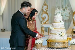Lovely capture Indian bride and groom cutting cake together. Lovely capture Indian bride and groom cutting cake together.