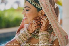 Sweet indian bride putting earrings on Sweet indian bride putting earrings on