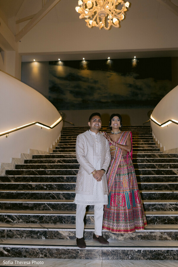 grand staircase,vibrant lehenga,white sherwani,elegant architecture,majestic pose,wedding night