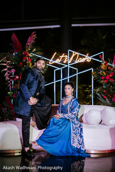 couple,lounge,modern decor,vibrant flowers,neon sign,celebration,relaxed pose,wedding,trendy,stylish