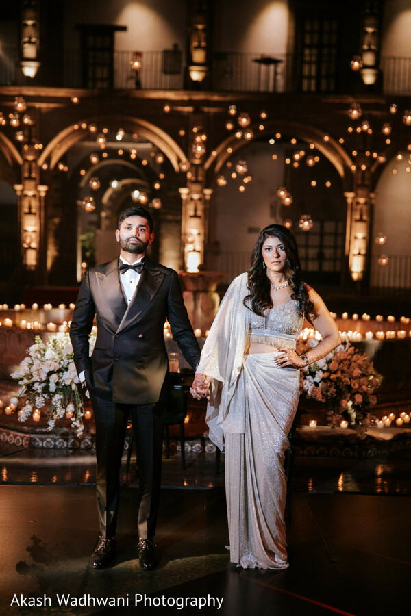 couple,grand venue,candles,traditional attire,modern elegance,regal,romantic,wedding,sophisticated,night