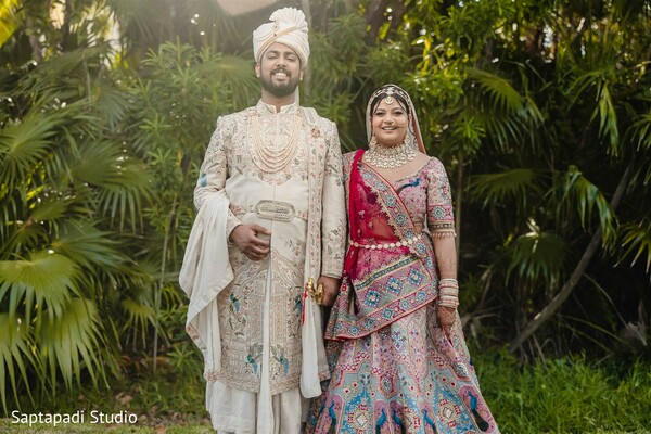 south asian wedding couple,bride and groom pose,embroidered lehenga,traditional sherwani,wedding elegance