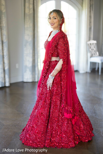 red bridal lengha,south asian bride,elegant wedding portrait,traditional beauty,henna hands