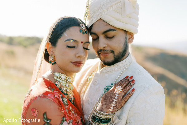 south asian couple,intimate wedding moment,red bridal lehenga,groom sherwani,peaceful pose