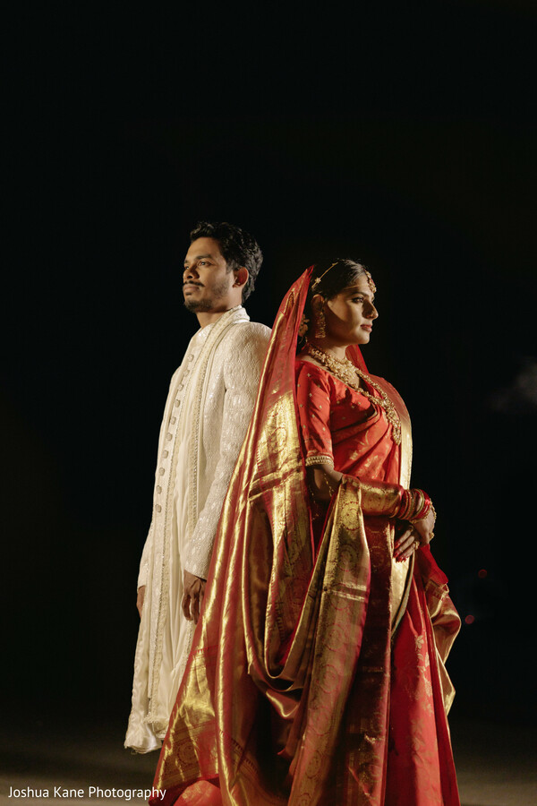 dramatic couple shot,night wedding portrait,red saree,white sherwani,indian bride and groom