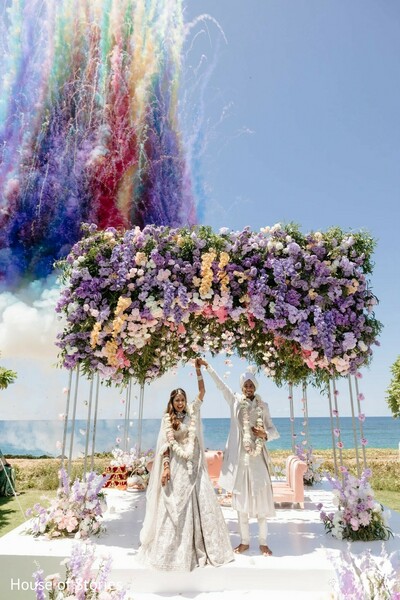 confetti wedding shot,colorful celebration burst,pastel floral mandap,beach wedding moment,bride and groom dance