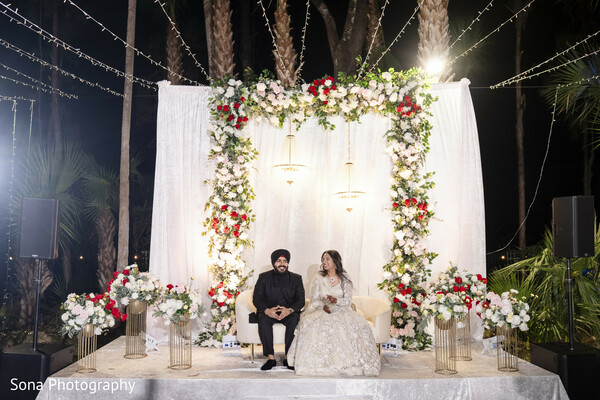 bride and groom seated,fairy light wedding,floral mandap,wedding celebration,tropical wedding decor