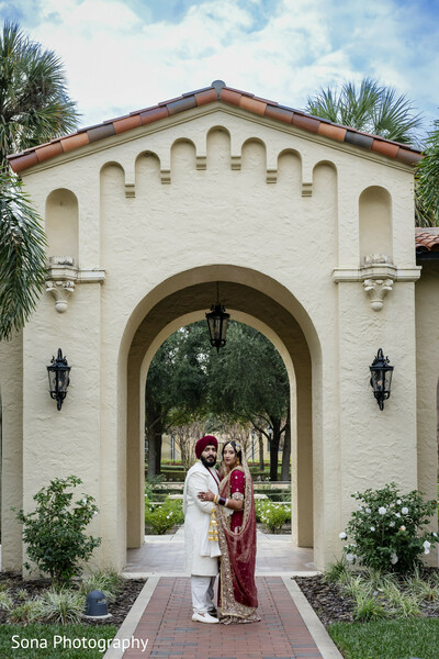 architectural wedding shot,indian couple portrait,spanish-style venue,wedding archway,bride and groom photo