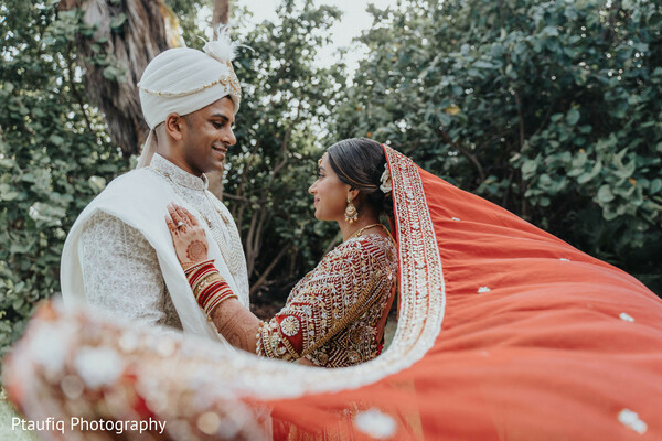 flowing dupatta,candid couple photo,red lehenga,indian wedding moment