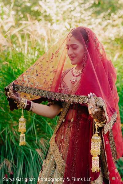 bridal portrait,lifting dupatta,green background,soft light,red bridal veil