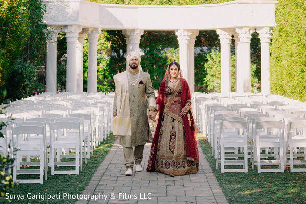 garden wedding aisle,bride and groom walk,red lehenga bride,ivory sherwani groom,romantic moment