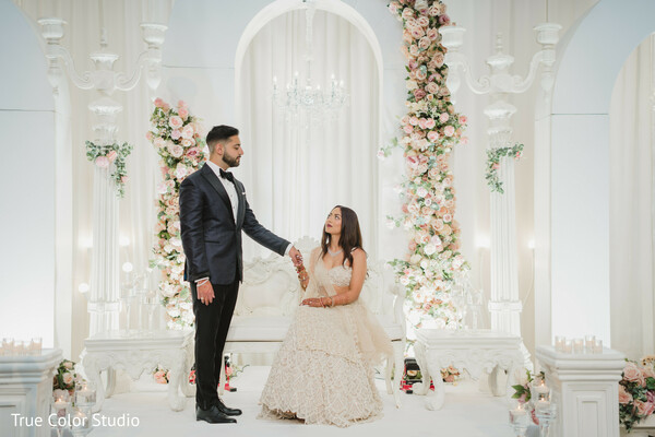 groom helping bride,fairytale wedding stage,soft pastel floral wedding,romantic wedding gesture