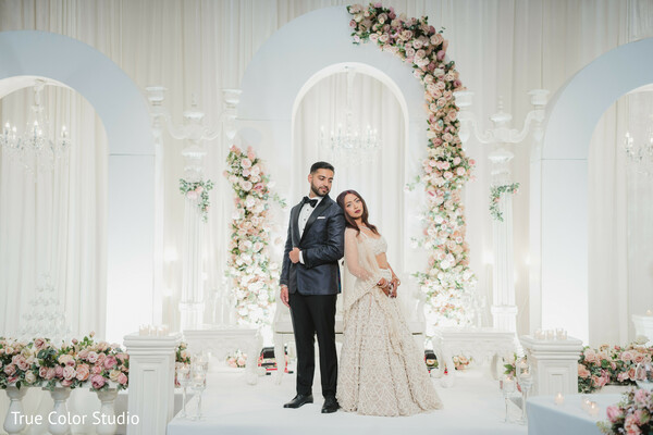 romantic wedding pose,luxury floral wedding stage,bride leaning on groom,dreamy wedding design