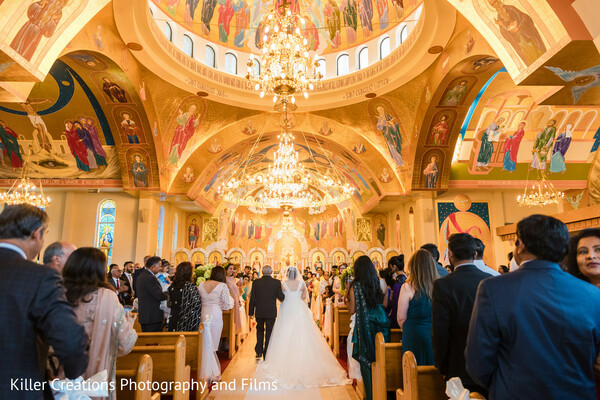 church wedding,grand aisle,bride walking,wedding ceremony,cathedral wedding,ornate ceiling,bridal entrance,sacred moment,traditional wedding,golden interior