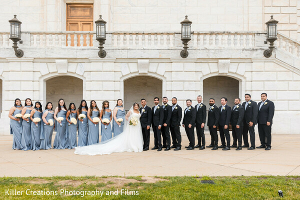 wedding party,bridal party photo,group wedding portrait,coordinated attire,bridesmaids and groomsmen,elegant formalwear,white stone building,full wedding crew,classic wedding look,timeless group shot