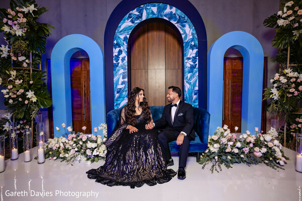 evening reception couple portrait,wedding stage design,royal blue wedding decor,indian couple regal photo,luxury wedding style,floral stage setup,modern indian wedding portrait
