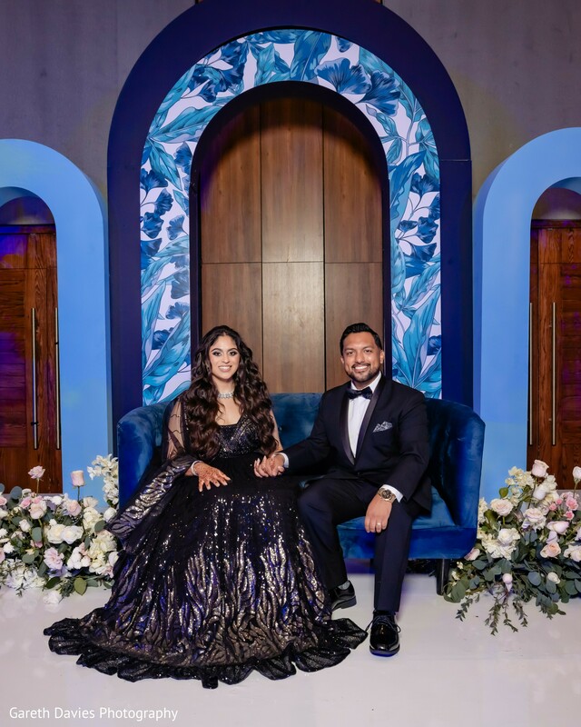 wedding couple sitting portrait,indian blue wedding stage,reception royal setup,couple regal shot,modern indian wedding photo,evening formal portrait