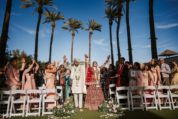 outdoor wedding,palm trees,wedding ceremony,bride and groom vows,colorful guest attire.