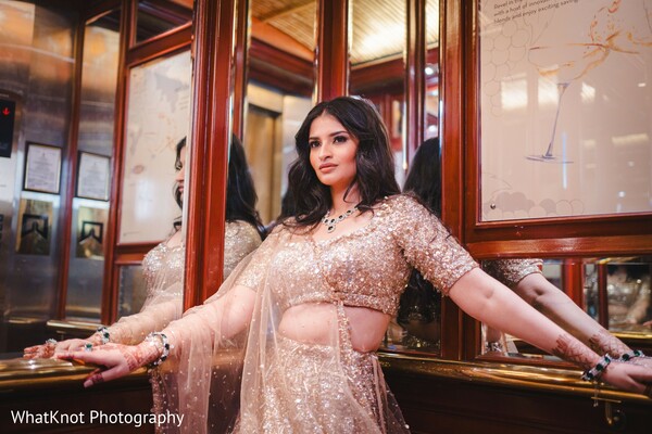 bride rose gold lehenga,indian bride at doorway,glamorous bridal portrait,indoor bridal fashion,regal bride in lehenga,indian wedding entrance moment,bridal fashion editorial