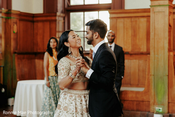 indoor wedding dance,romantic moment,wood panel backdrop,couple dancing,warm lighting