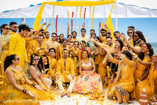 haldi celebration,beach wedding,group joy,marigold decor,indian pre-wedding ceremony