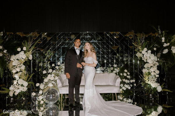 wedding reception,bride and groom,formal wear,nighttime wedding,floral stage,romance