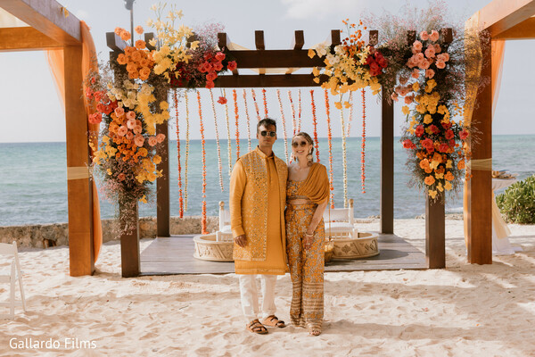 haldi outfit,yellow attire,couple moment,indian wedding,floral arch
