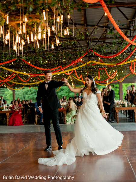 first dance,reception highlights,string lights decor,indoor celebration,joyful couple,indian-western wedding fusion