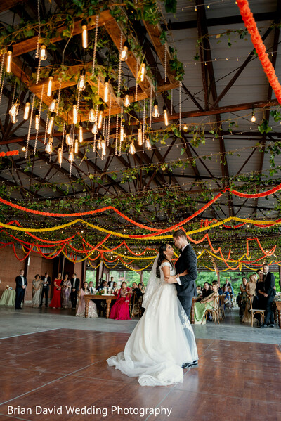 bride dancing,indoor reception,chandeliers and drapes,elegant movement,bridal gown,modern celebration