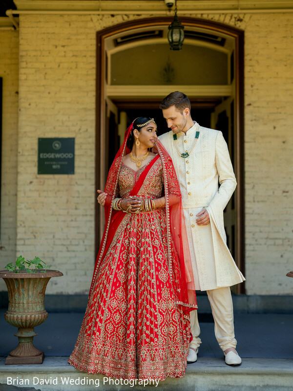 indian bride,red lehenga,cream sherwani,vintage architecture,wedding portrait,regal couple,fusion wedding