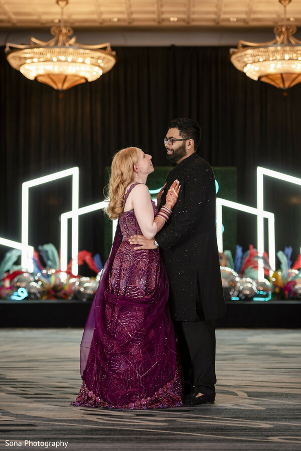 reception dance,couple dancing,neon backdrop,chandeliers,wedding joy,intimate moment