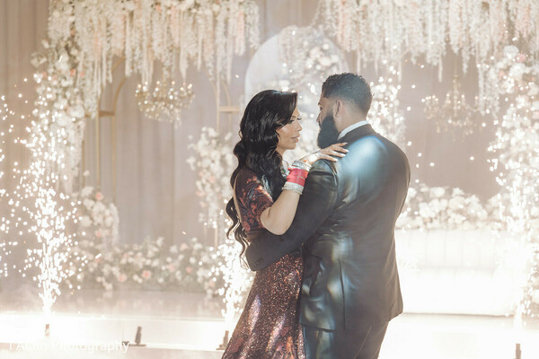 first dance couple,indoor wedding fireworks,reception love moment,dramatic wedding lighting,couple dancing,romantic indian wedding,sparkling dance floor,bride in red,wedding reception glam,cinematic wedding photo