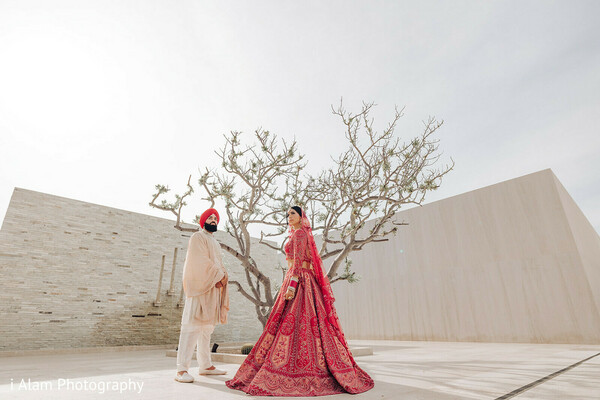 couple and tree shot,symbolic wedding image,sikh couple moment,red and white outfits,bride groom by tree,artistic wedding photography,outdoor love scene,couple in balance,traditional attire elegance,indian love story