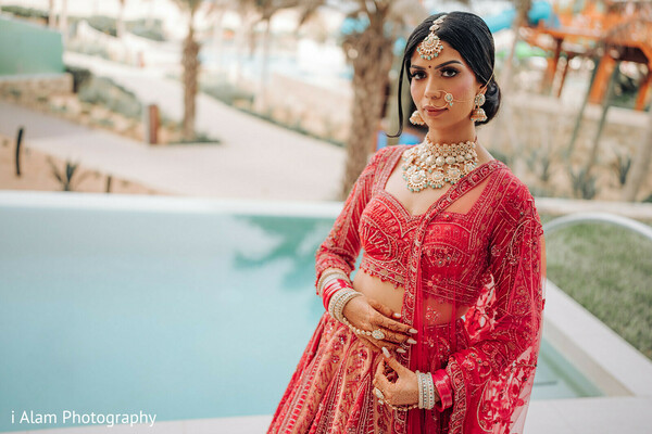 bride by pool,red lehenga fashion,sikh bride posing,bridal portrait elegance,wedding by water,poolside wedding style,indian bridal couture,destination wedding glamour,poised bridal shot,fashion-focused bride