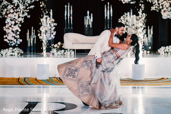 reception dance dip,bride groom dance move,indian wedding dance floor,elegant dip photo,glamorous wedding moment,floral backdrop wedding,romantic spin,couple dancing,wedding choreography,dramatic wedding pose