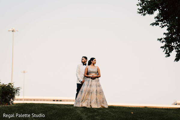 wide wedding portrait,bride groom outdoors,natural wedding vibe,indian wedding couple in field,romantic scenery wedding,tree-lined portrait,outdoor wedding shoot,couple and nature,peaceful love moment,earthy wedding theme