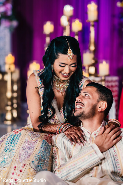 bride groom fun moment,reception laughter photo,playful wedding couple,wedding humor shot,indian bride laughing,fun loving wedding,south asian reception joy,candid wedding love,bride groom togetherness,colorful reception backdrop