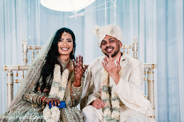 double bride photo,two brides together,south asian wedding fun,complementary bridal looks,joyful wedding moment,bridal friendship,indian wedding couch photo,colorful bride attire,wedding day laughter,bridal bond