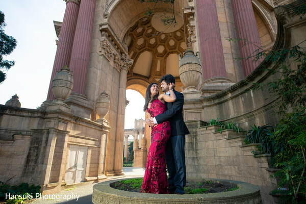 couple at archway,palace of fine arts portrait,indian couple dramatic pose,golden hour wedding photo,historic architecture shoot,romantic indian engagement,elegant wedding backdrop,burgundy bride gown,groom formalwear photo,powerful love image